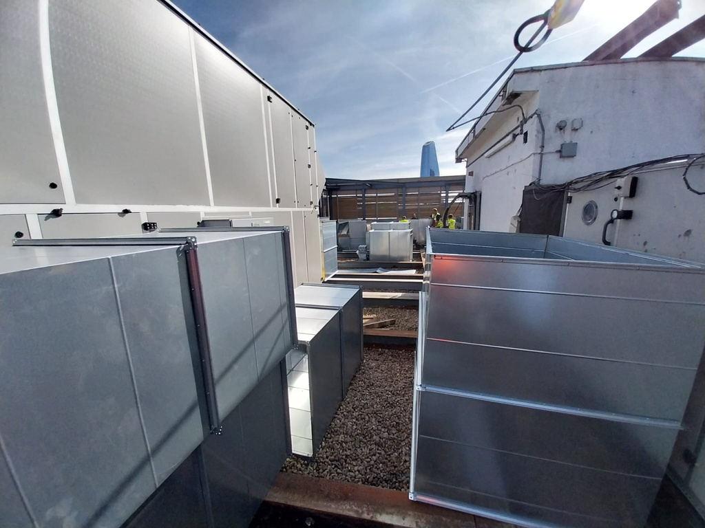 Installed AHU casing on Blackfriars office rooftop with ductwork connections being made