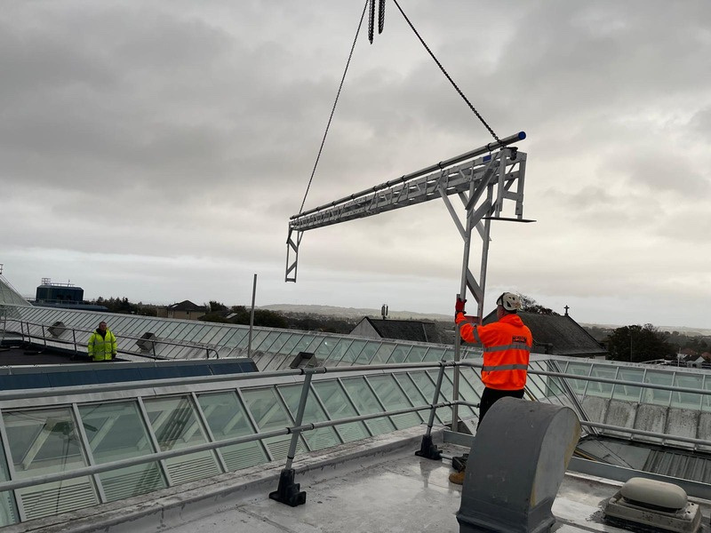 Crane lifting bridge scaffold over Newton Mearns Shopping Centre glass roof for gas pipework installation