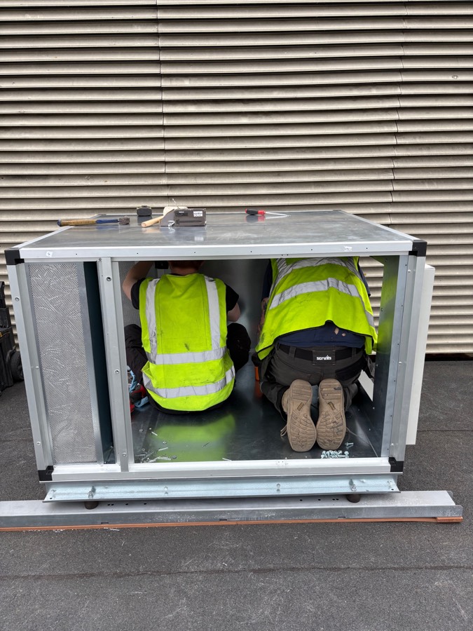 Engineers fitting the new kitchen extract unit during the ventilation upgrade at a Plymouth hotel