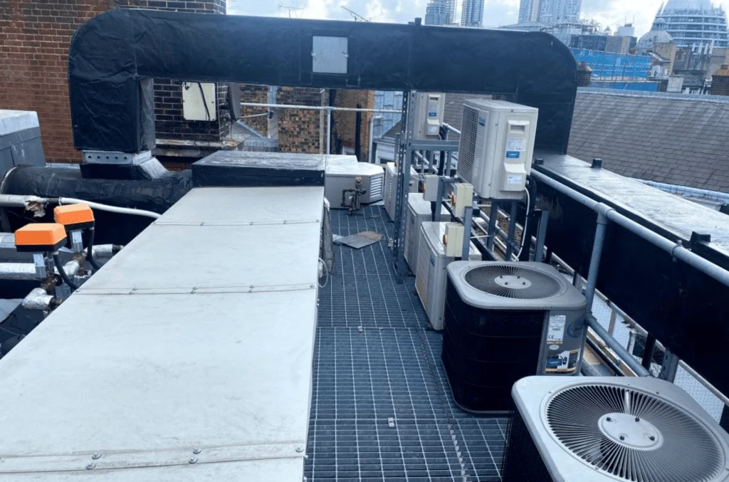 The roof of a building accompanied by an Handling Unit, Two Fans and ductwork.